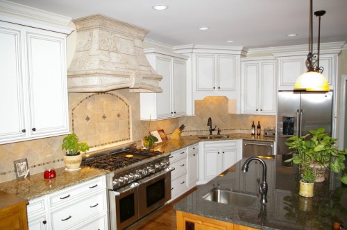 Quality Really Is Job #1 Photo of completed major kitchen remodel project showing large gas range, custom tile backsplash and new granite island with updated sink faucet