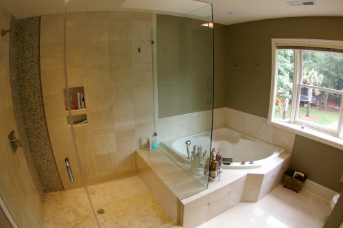 After bathroom renovation with view of new walk-in tile shower and tub