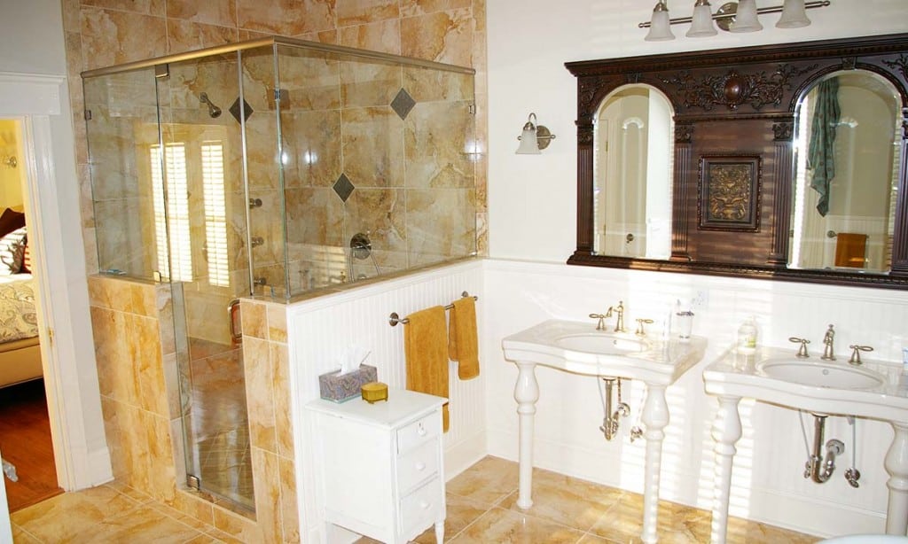 New and beautiful bathroom with view of his and her vanities and custom walk-in tile shower