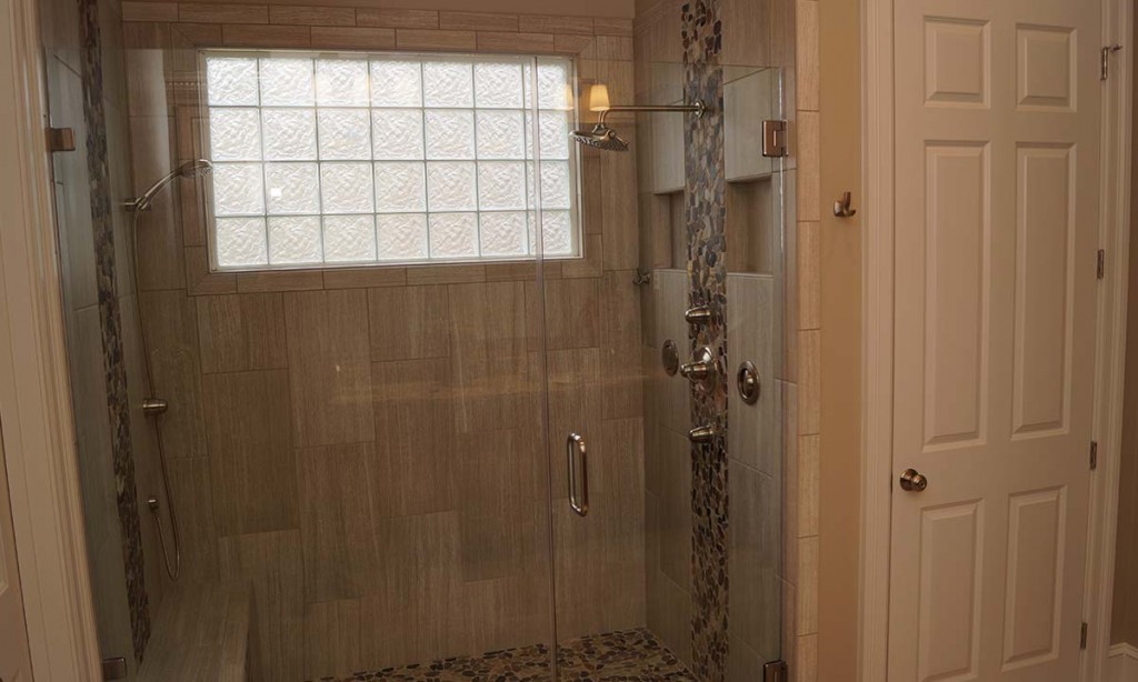 New shower with beautiful tilework and frameless glass complete the high-end look