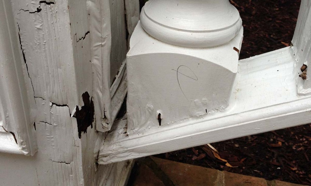 Close-up of front porch railing damage and wood rot