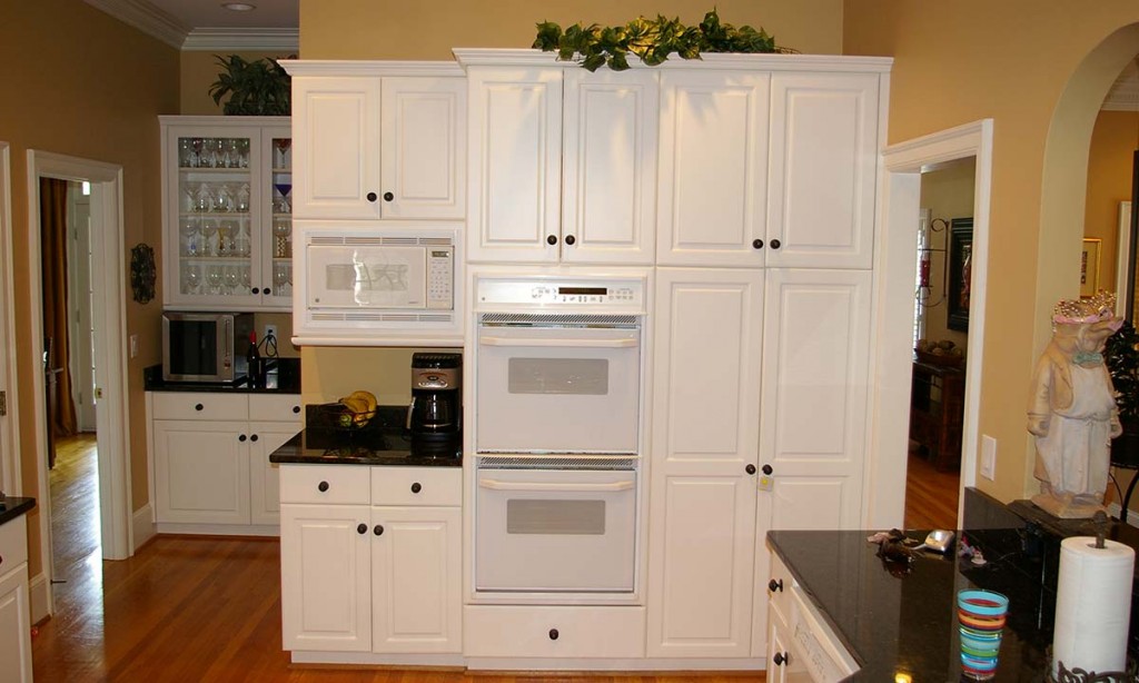 Dated and peeling white thermofoil cabinets before the remodel