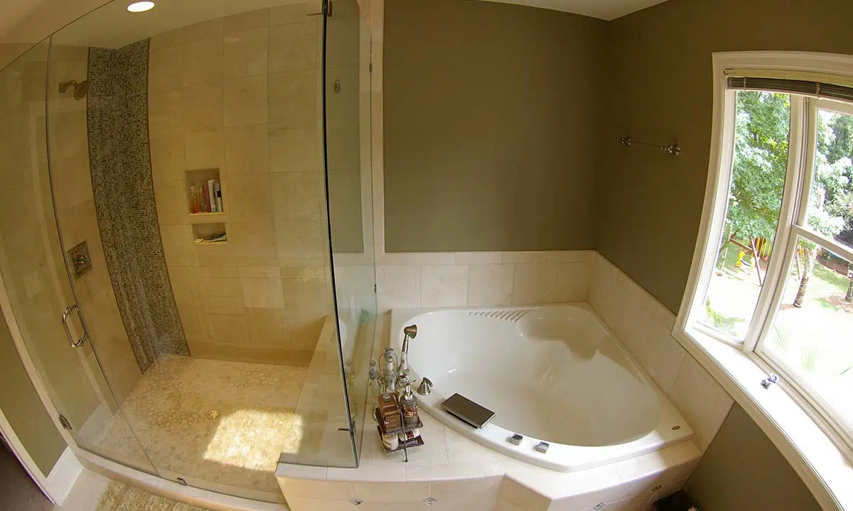 Finished master bathroom remodel with view of tub and shower