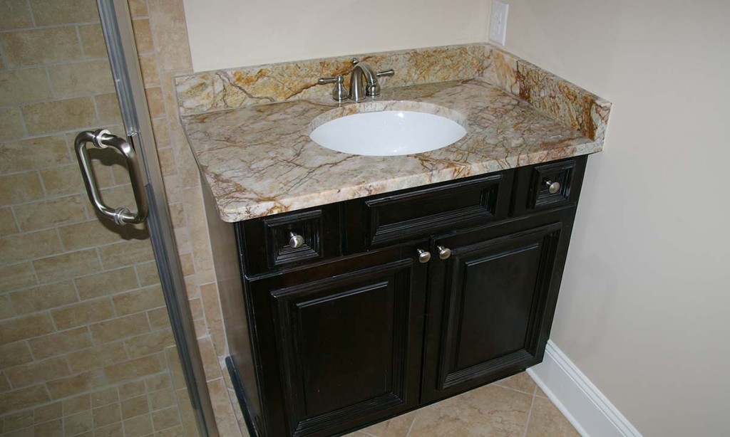 Picture of new full bathroom with granite sink and angled walk-in shower