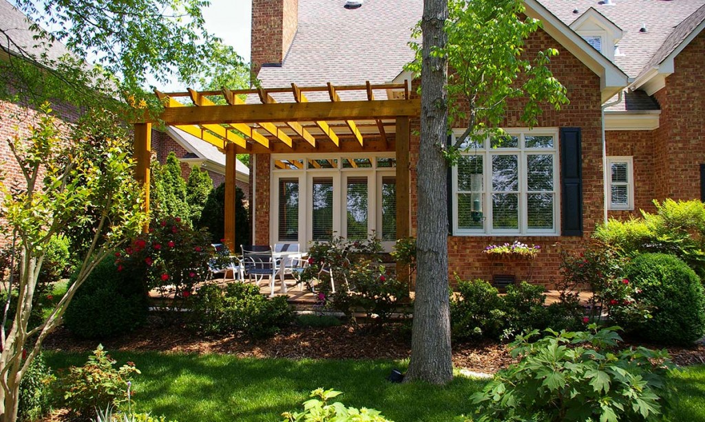 Photo of the new rough-sawn, cedar-beamed pergola anchored to house