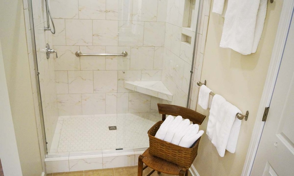 New and larger walk-in tile shower with grab bar for safety