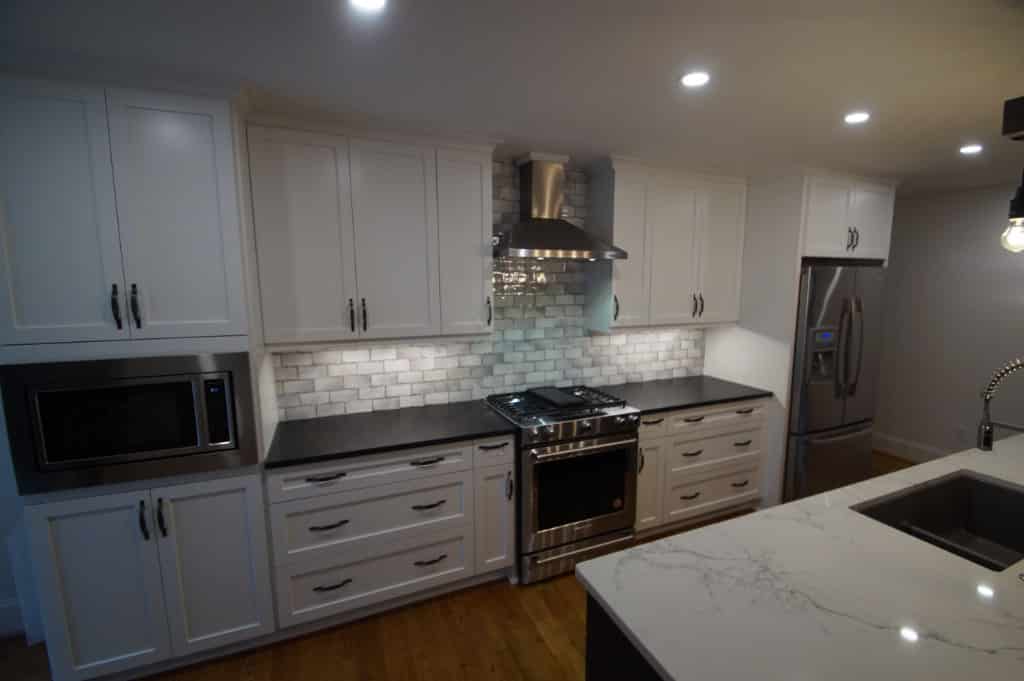 after photo of kitchen remodel with white cabinets and marble countertops