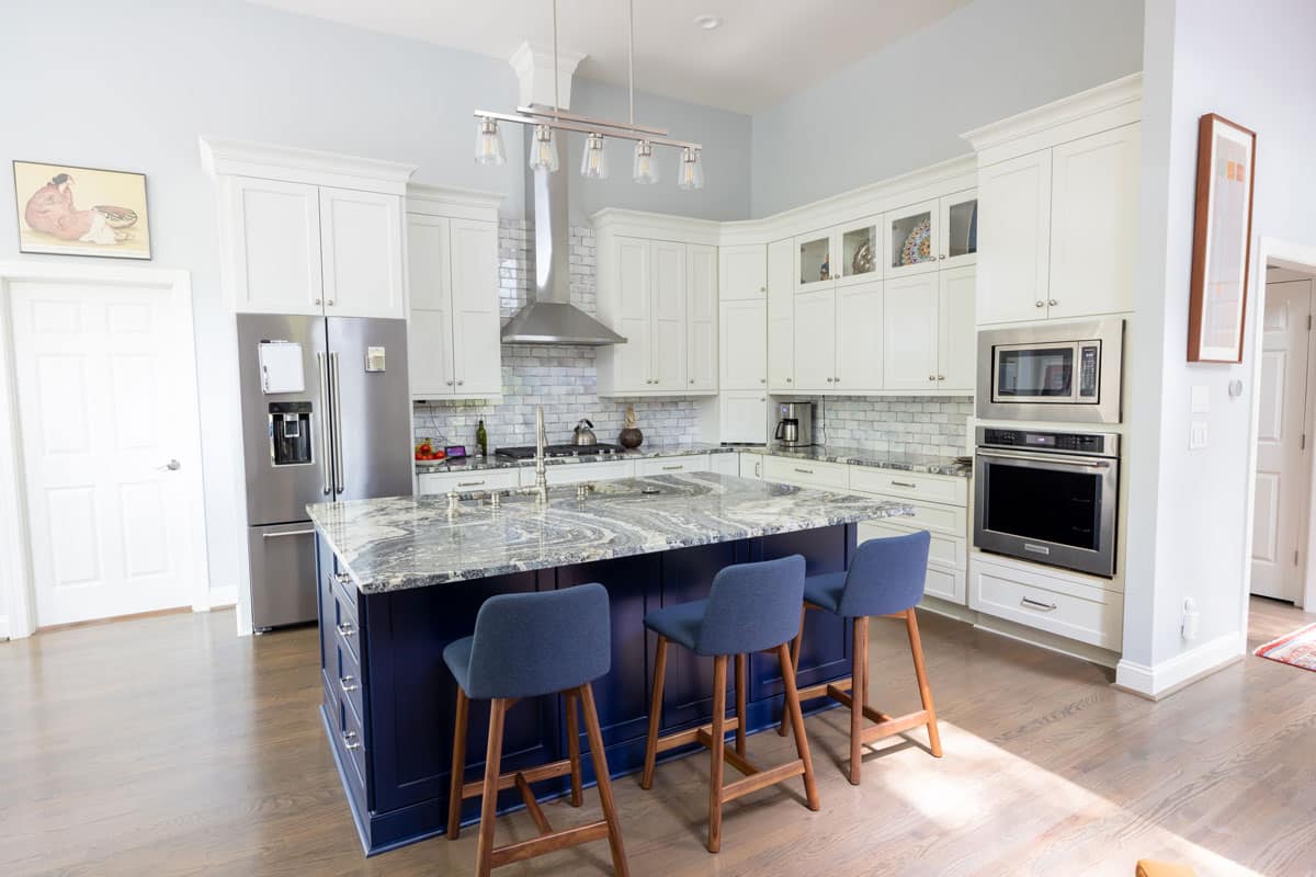 after photo of kitchen remodel with navy blue island and granite countertops