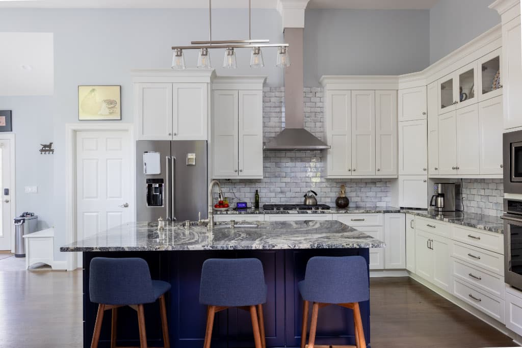 kitchen remodel with white cabinets and royal blue island with blue bar stools