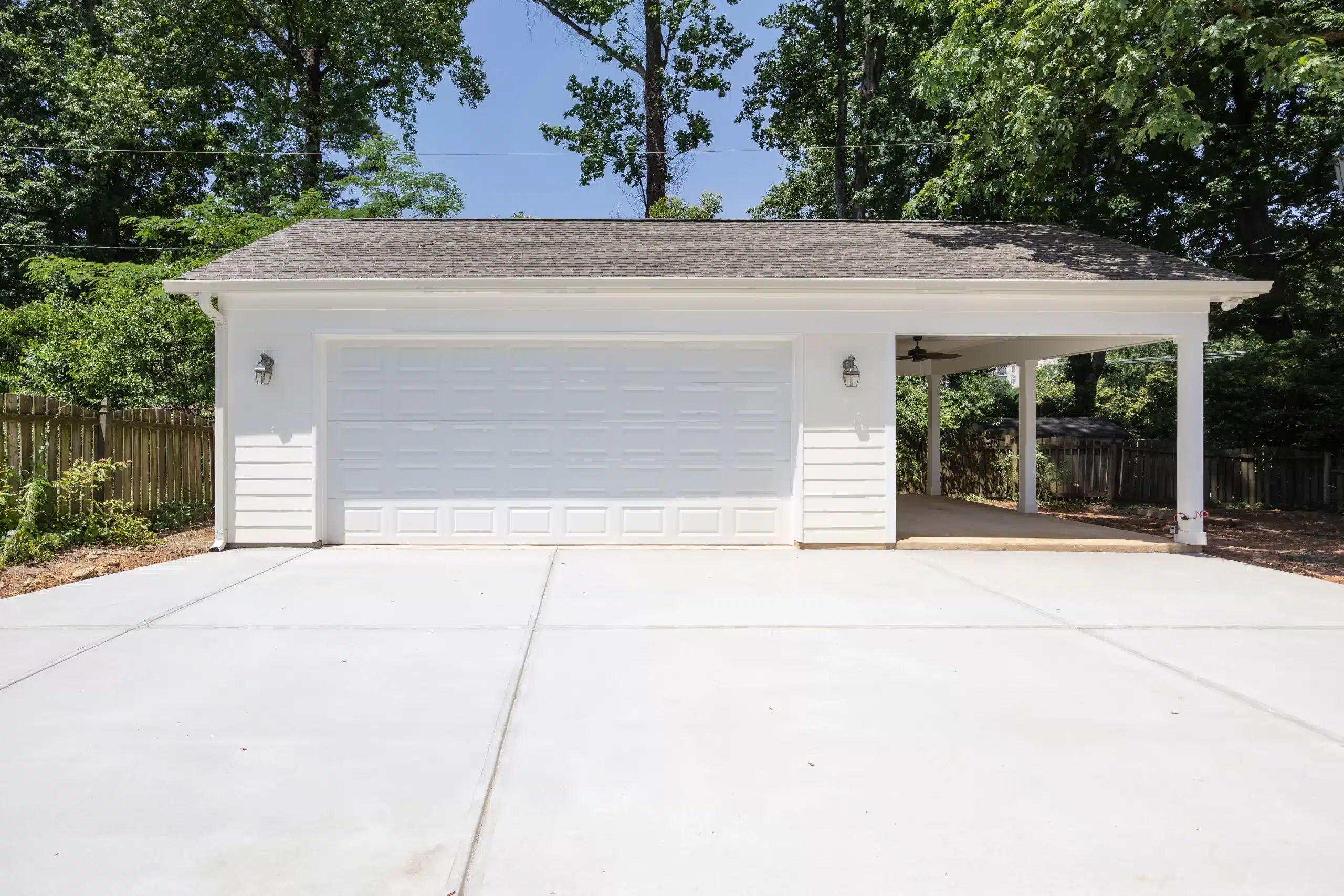 view of garage addition with white exterior with a covered working area to the side
