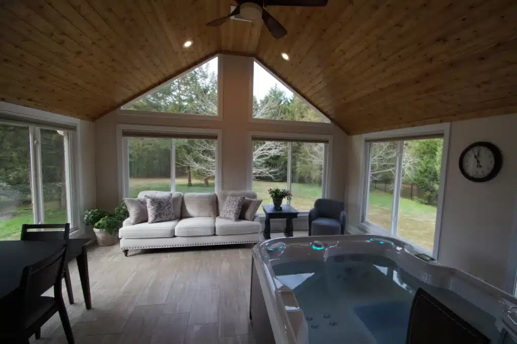 hot tub in sunroom with white couch