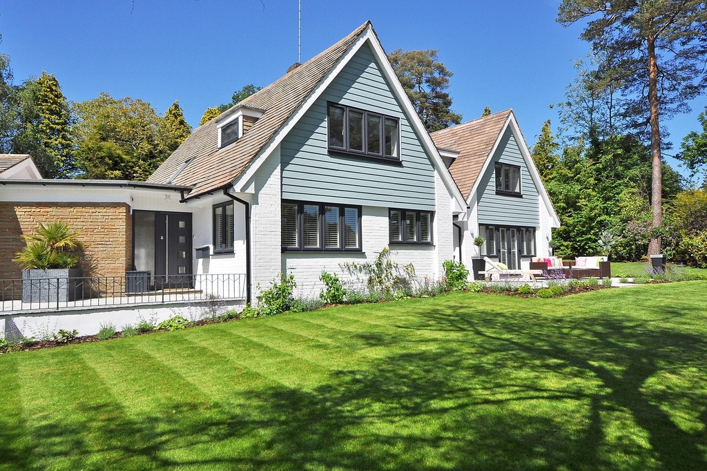 charming modern meets cottage style home surrounded by large lawn of freshly mowed grass
