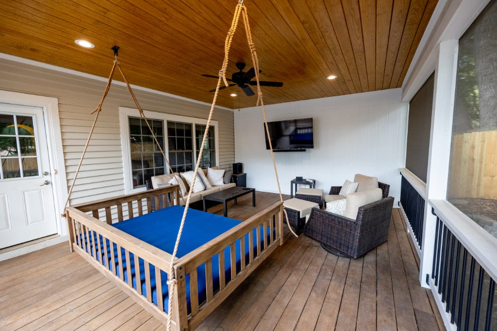 oversized porch swing in screened-in porch in front of flat screen tv