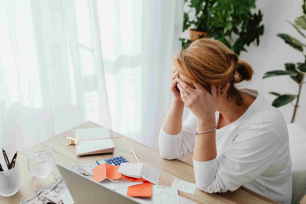 woman with head in her hands overwhelmed at her desk