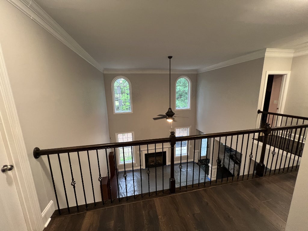 before photo of floor over with tall ceilings with upstairs hallway looking over living room