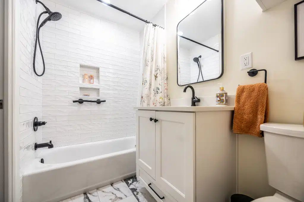 remodeled small bathroom with one sink vanity and tiled tub shower