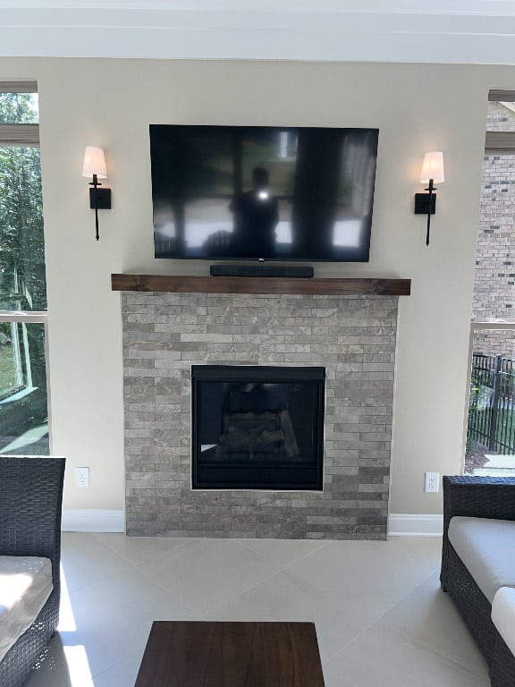 sunroom fireplace with mantel and flat screen tv