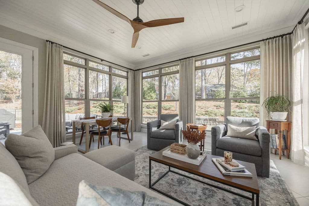 view of floor to ceiling windows in sunroom looking out into large yard