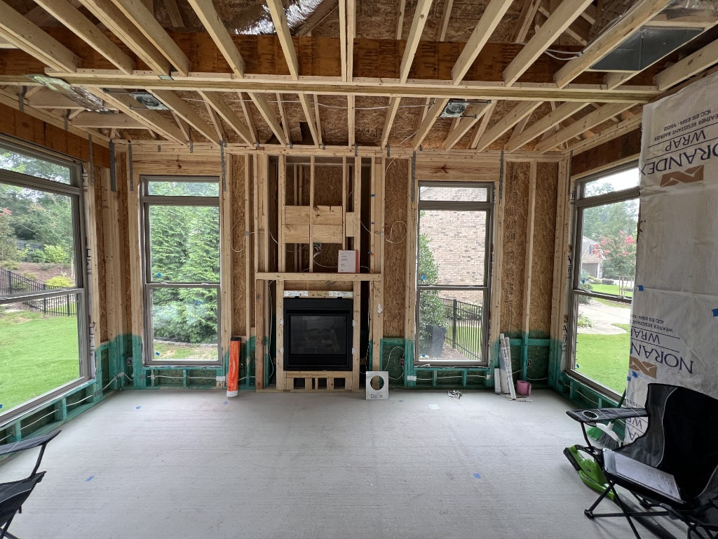 in-process home renovation with just 2x4 planks framing living room and fireplace