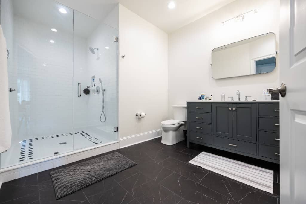 primary bathroom with stand up shower glass shower and bathroom with double sink