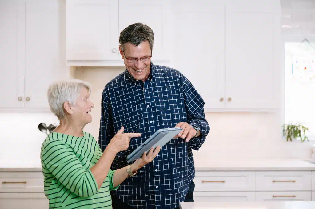 Gary Palmer smiling with client looking over remodeling plans
